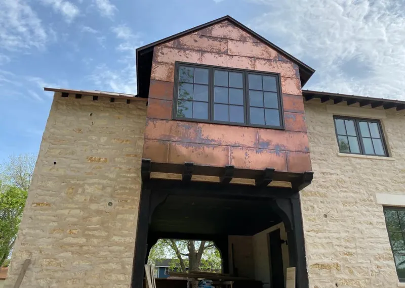 Copper metal panel facade on a stone building for Skylight Installation in Joplin