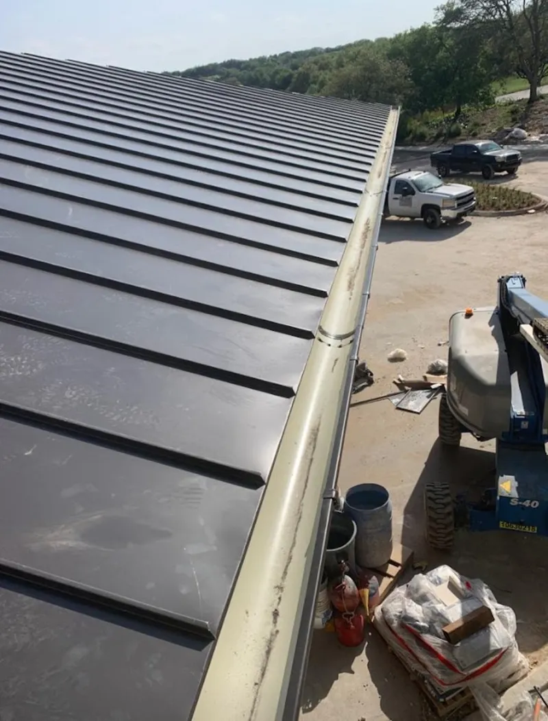 Standing seam panel and gutter detail on a metal roofing jobsite in Joplin